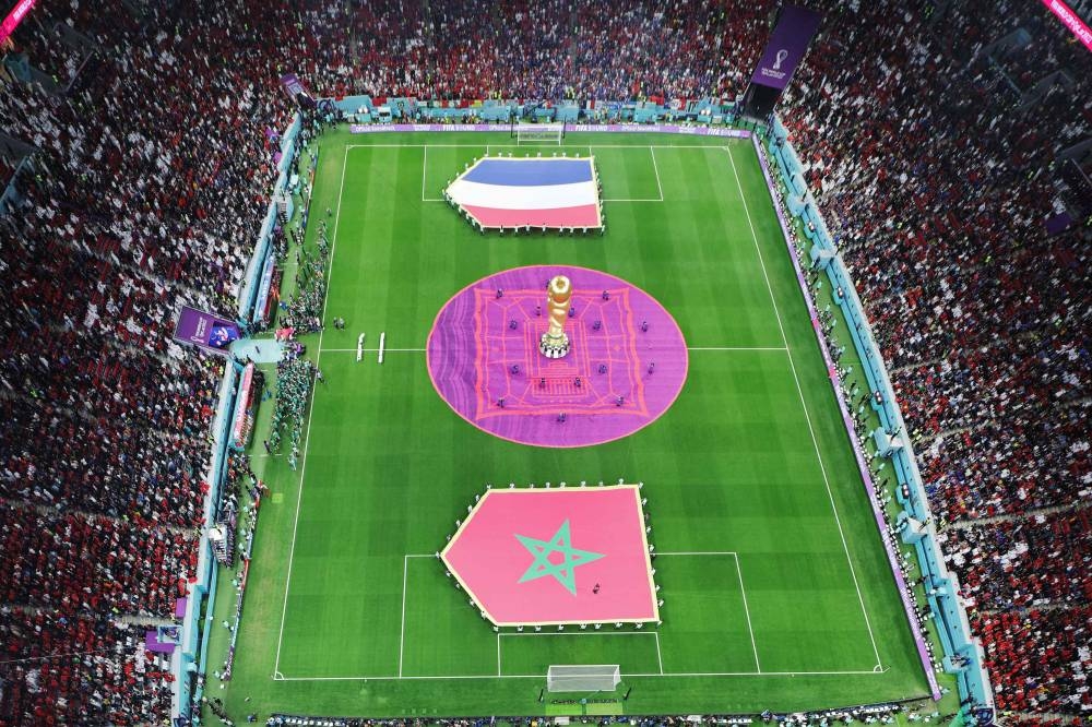 A general view shows giant French and Moroccan national flags displayed on the pitch ahead of the Qatar 2022 World Cup semi-final football match between France and Morocco at the Al-Bayt Stadium in Al Khor, north of Doha on December 14, 2022. (Photo by Giuseppe CACACE / AFP)