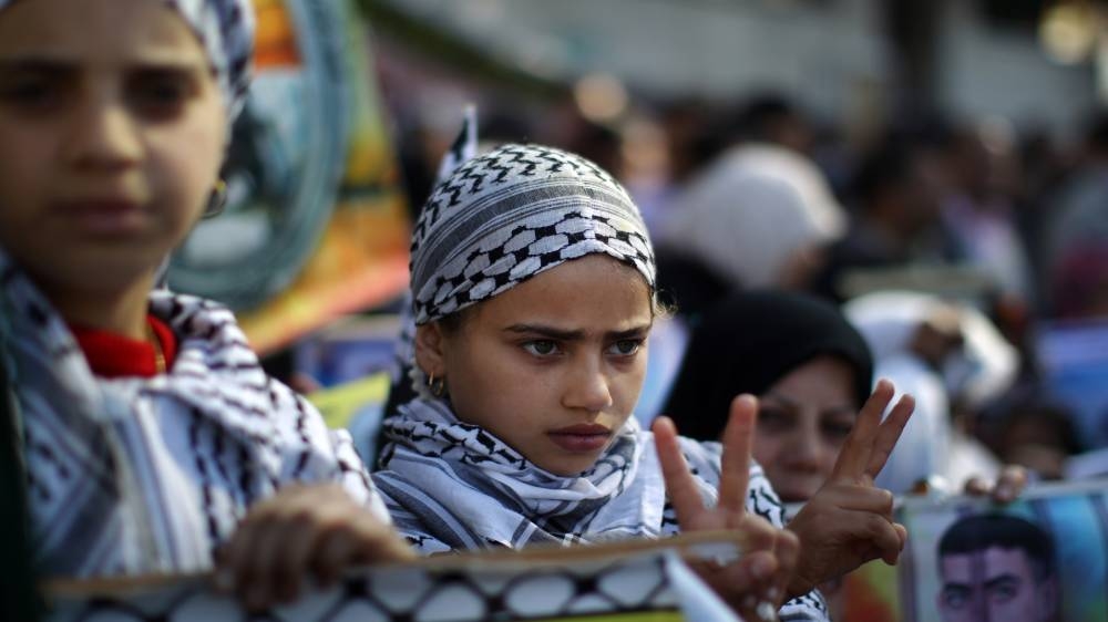 A Palestinian girl flashes the "V" for victory sign during a protest calling for the release of Palestinian prisoners from Israeli jails outside the International Red Cross offices  in Gaza City on January 21, 2013. AFP PHOTO/MAHMUD HAMS        (Photo credit should read MAHMUD HAMS/AFP/Getty Images)