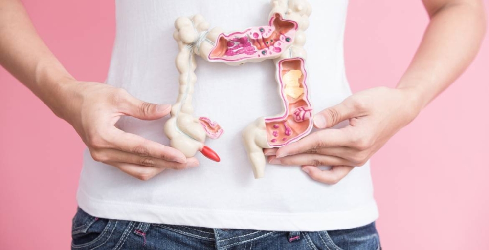 woman with colorectal cancer concept on the pink backgorund