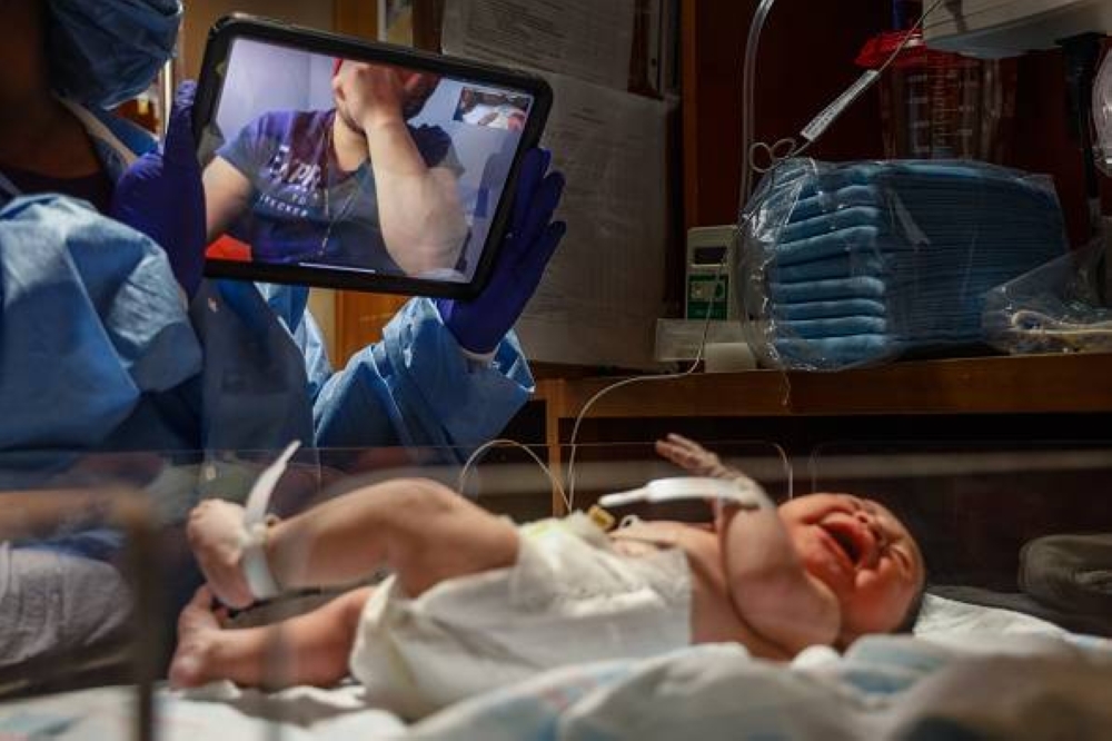 Oceanside, N.Y.: Manuel Carchipulla, who tested positive for COVID-19 earlier in the morning and was not permitted to attend the birth of his child Danaey, cries while saying «te amo» to his daughter via FaceTime, at Mount Sinai South Nassau in Oceanside, New York on April 28, 2020. (Photo by Jeffrey Basinger/Newsday RM via Getty Images)